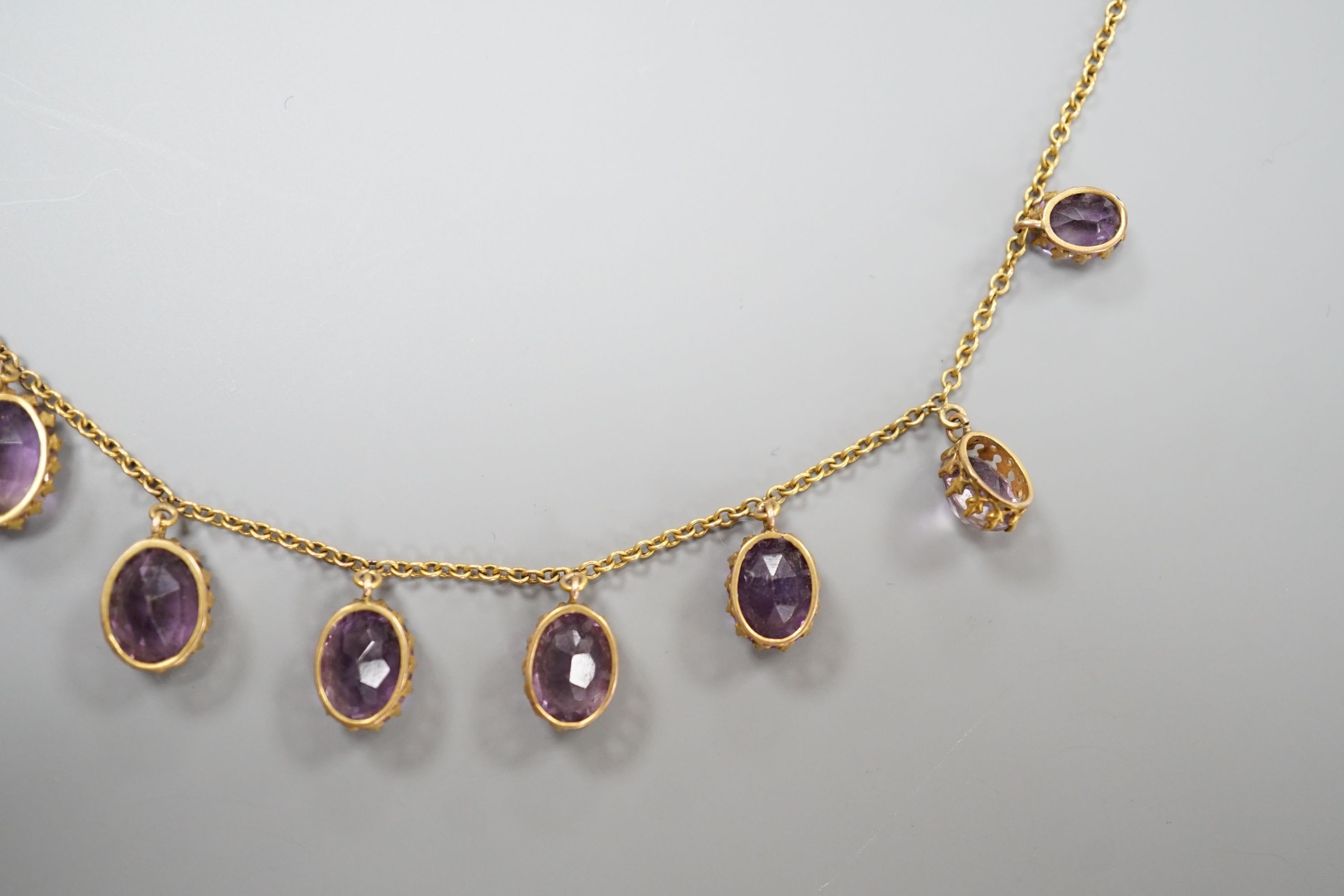 An early 20th century 9ct and graduated oval cut amethyst set drop fringe necklace, 45cm, gross weight 11.8 grams.
